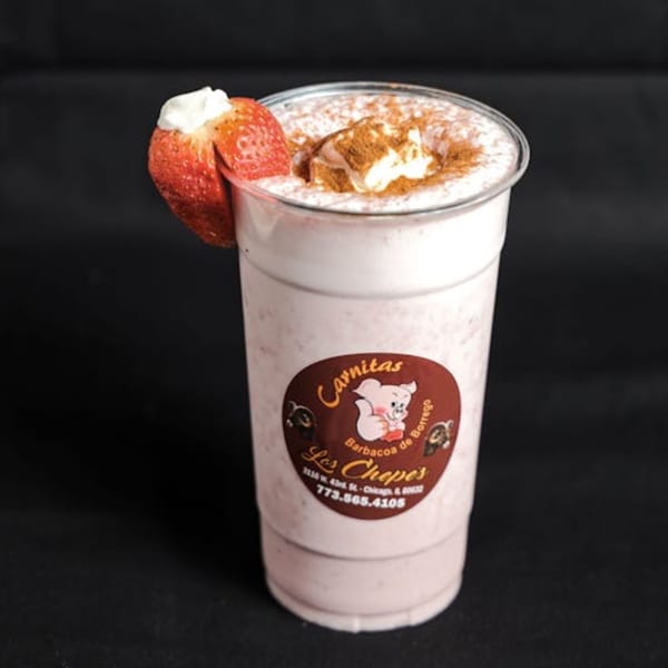 A strawberry milkshake from Los Chepes, topped with whipped cream, cinnamon, and a fresh strawberry.