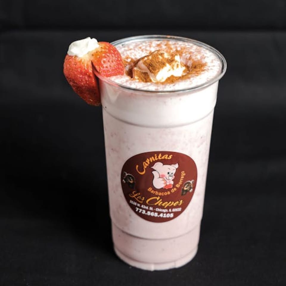 A strawberry milkshake from Los Chepes, topped with whipped cream, cinnamon, and a fresh strawberry.